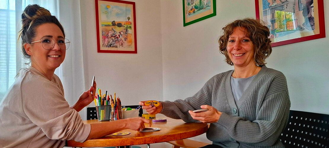 Frau Eisinger und Frau Dechant sitzen an einem runden Tisch