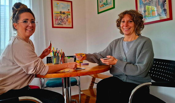 Frau Eisinger und Frau Dechant sitzen an einem runden Tisch